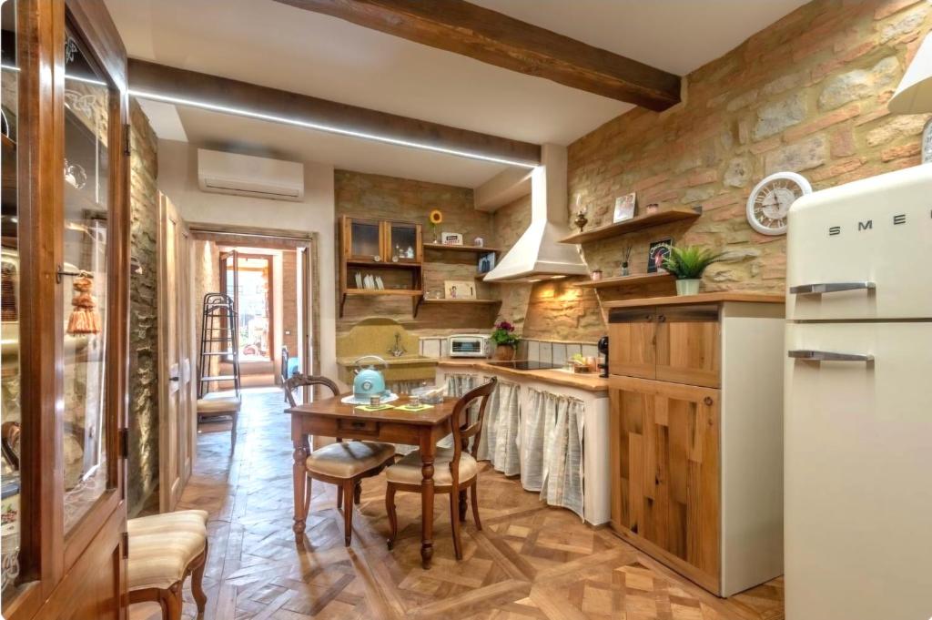 a kitchen with a table and a refrigerator at Il Girasole -with Garden- in Buonconvento
