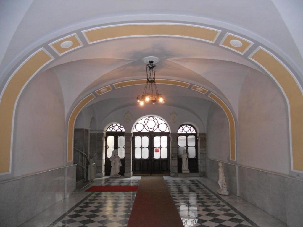 an empty hallway with a chandelier in a building at Palazzo Brigido Apartment in Trieste