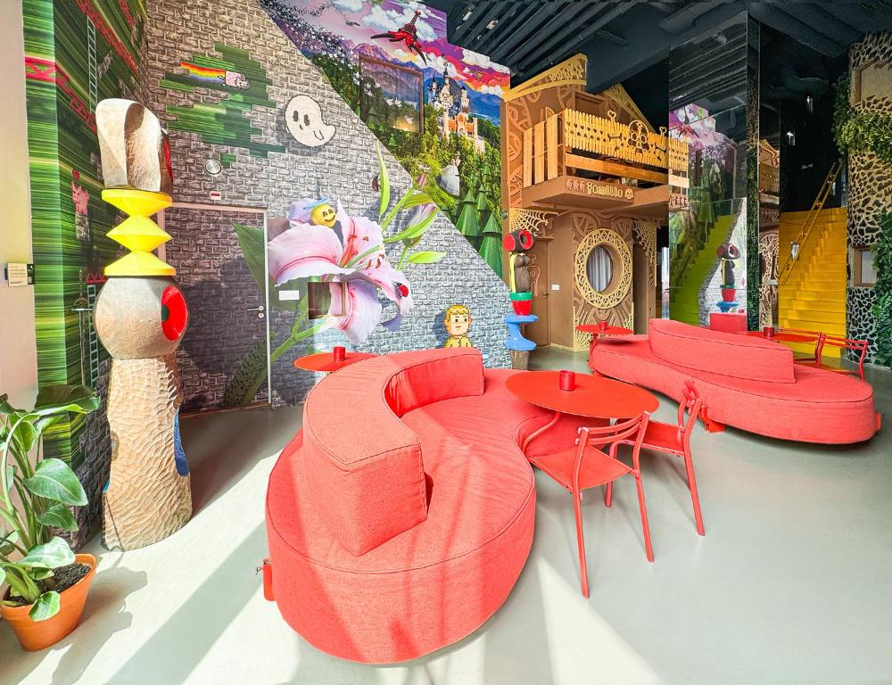 a room with red furniture and a table and chairs at Hotel Not Hotel Rotterdam in Rotterdam