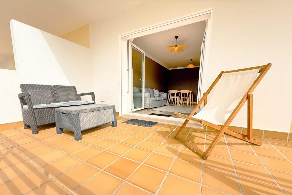 a living room with a chair and a table at Marta Apartment - Balcony, Patio, Pool in Ferrel