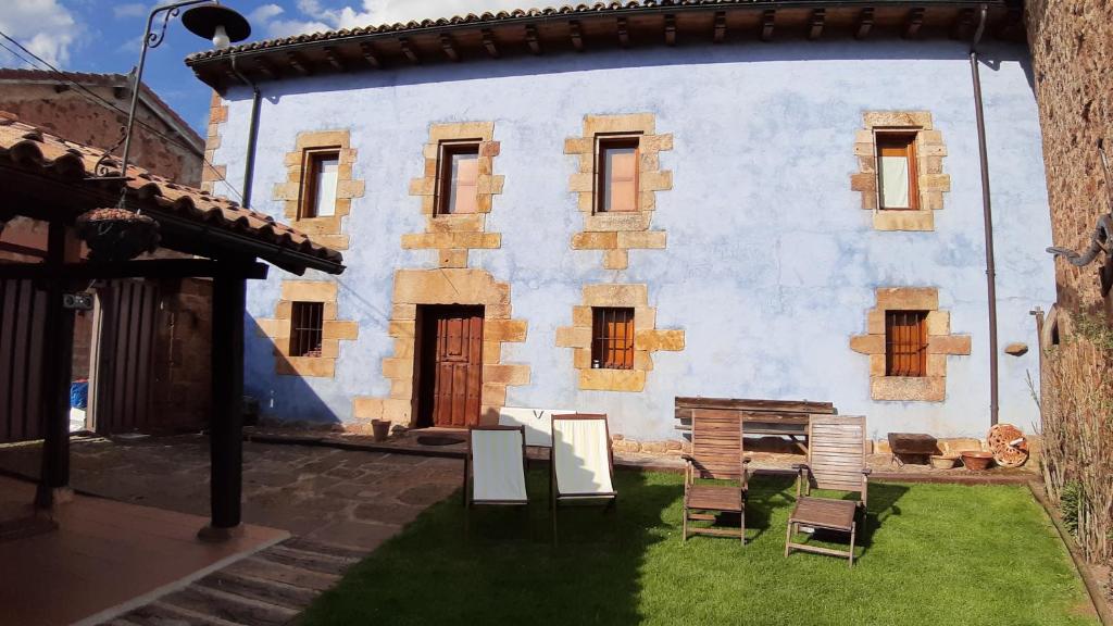 a house with chairs in front of it at CASA RURAL MATÉ in Susilla