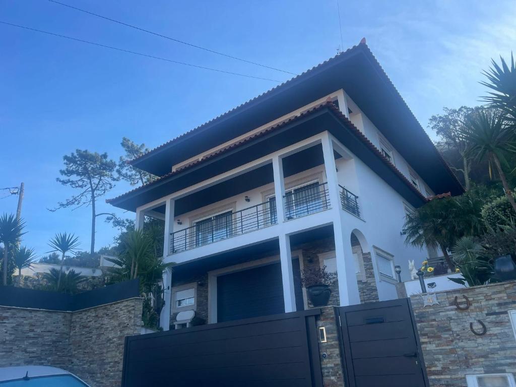 a house with a gate in front of it at Moradia Com Piscina T4 in Esposende