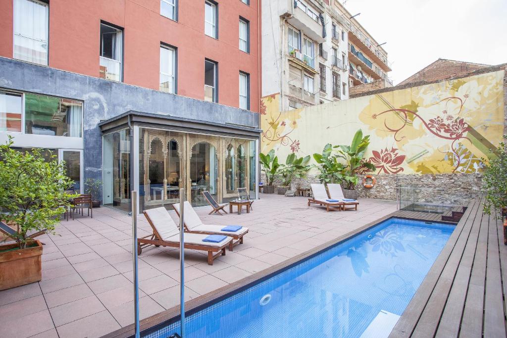 a patio with a pool and chairs and a building at Hotel Onix Liceo in Barcelona