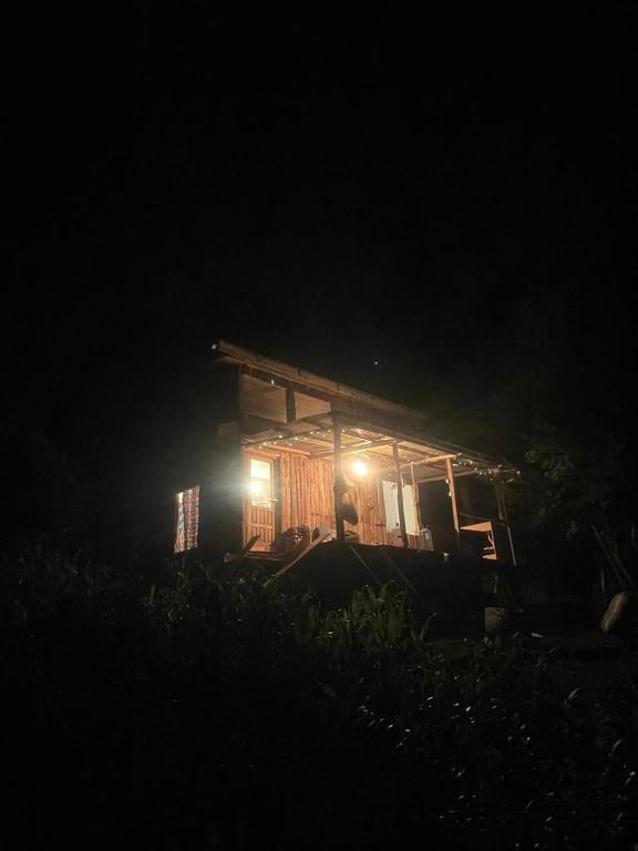 a small wooden cabin with lights in the dark at Ndege Cottage in Mai Mahoro