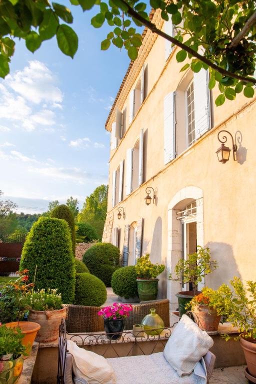 a house with potted plants in front of it at Le Vieux Castel in Roumoules