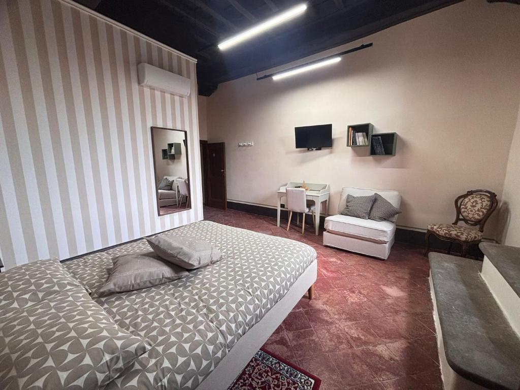 a bedroom with a bed and a chair and a table at Barberini Guest House Palestrina in Palestrina