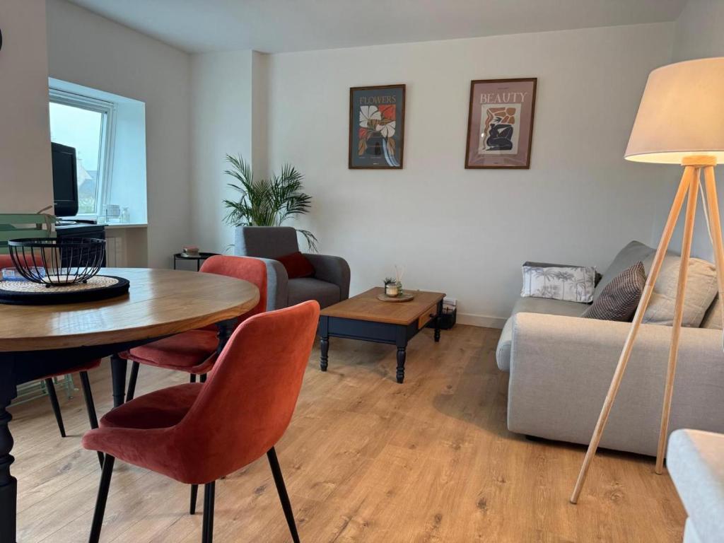 a living room with a table and a couch at Les Trinitaires in Sarzeau