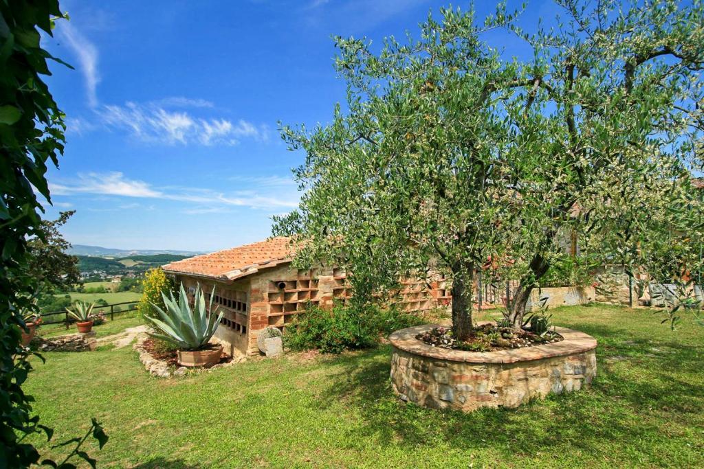 a house with a tree in a yard at Casalecchi - Cottage between Siena & Florence in Poggibonsi