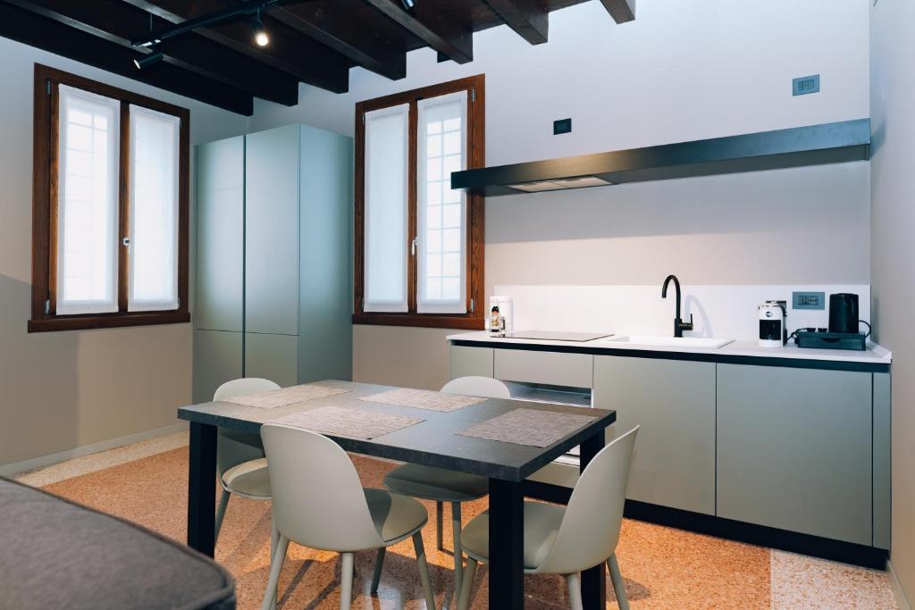a kitchen with a black table and chairs at Legnago Suite Apartments in Legnago