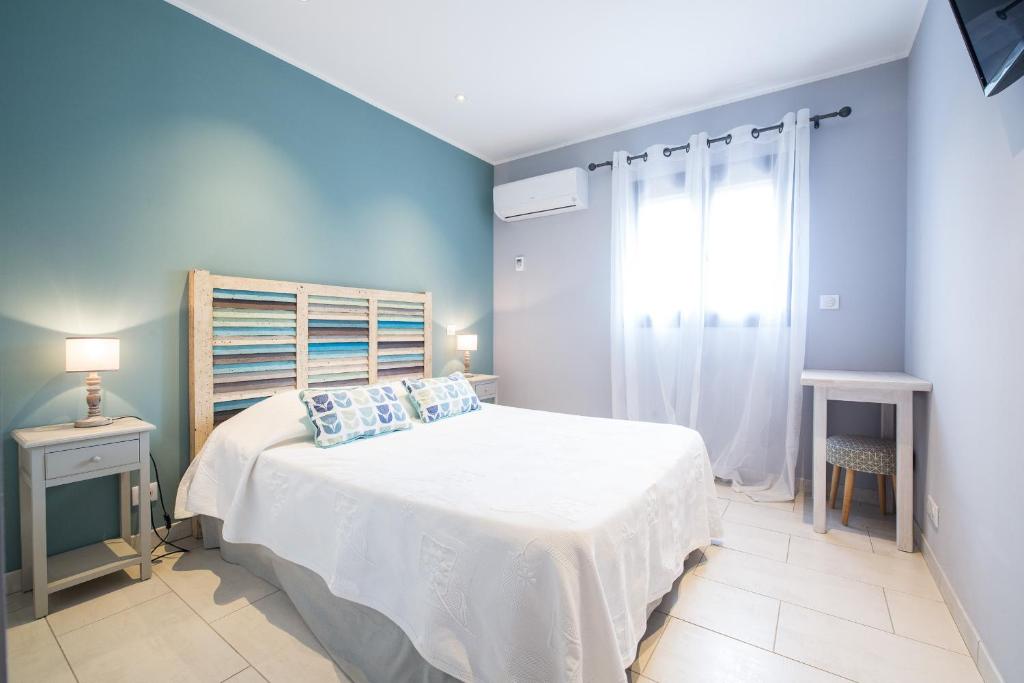 a bedroom with a white bed and a window at U Fornu in Patrimonio