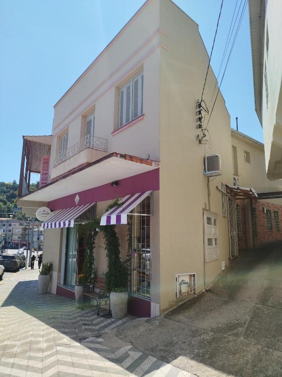 a white building with a purple awning on it at Casa da Nona in Garibaldi