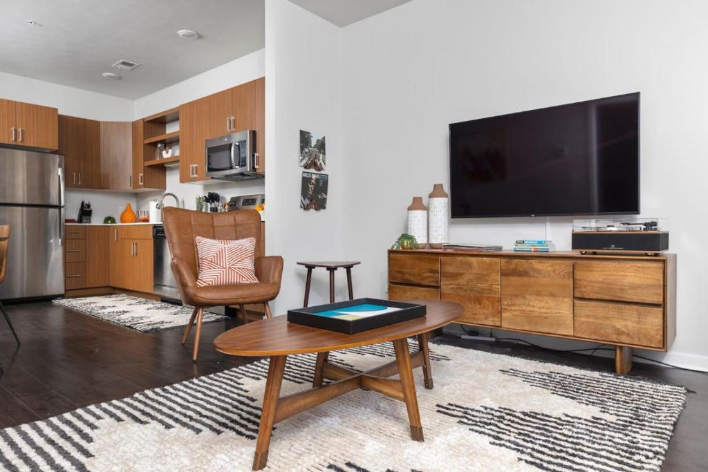 a living room with a large television and a table at The Pendleton Boutique Stylish 1 bedroom Condo in Traverse City