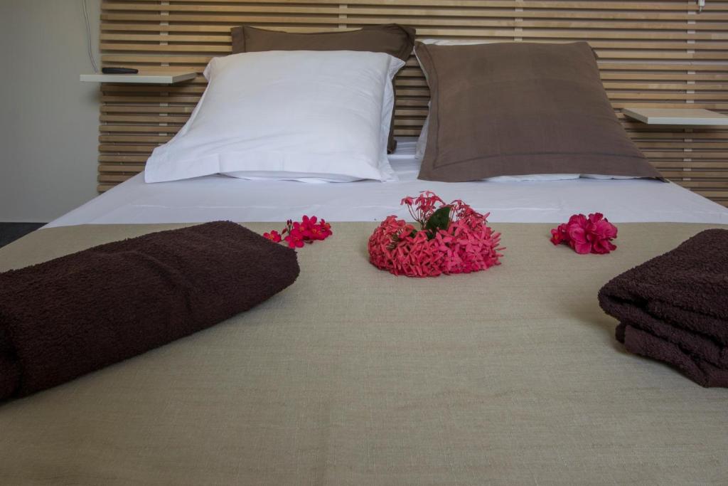 a bed with pink flowers on top of it at Leu Pied Dans L&#39;Eau in Saint-Leu