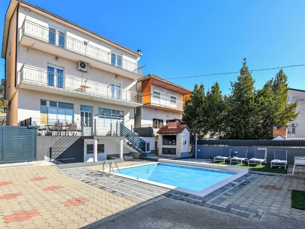 a house with a swimming pool in front of it at Apartment Dijana by Interhome in Donji Proložac