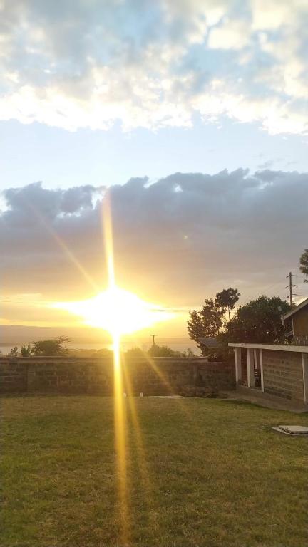 a sunset with the sun setting in a field at Kings Home Stay in Nakuru
