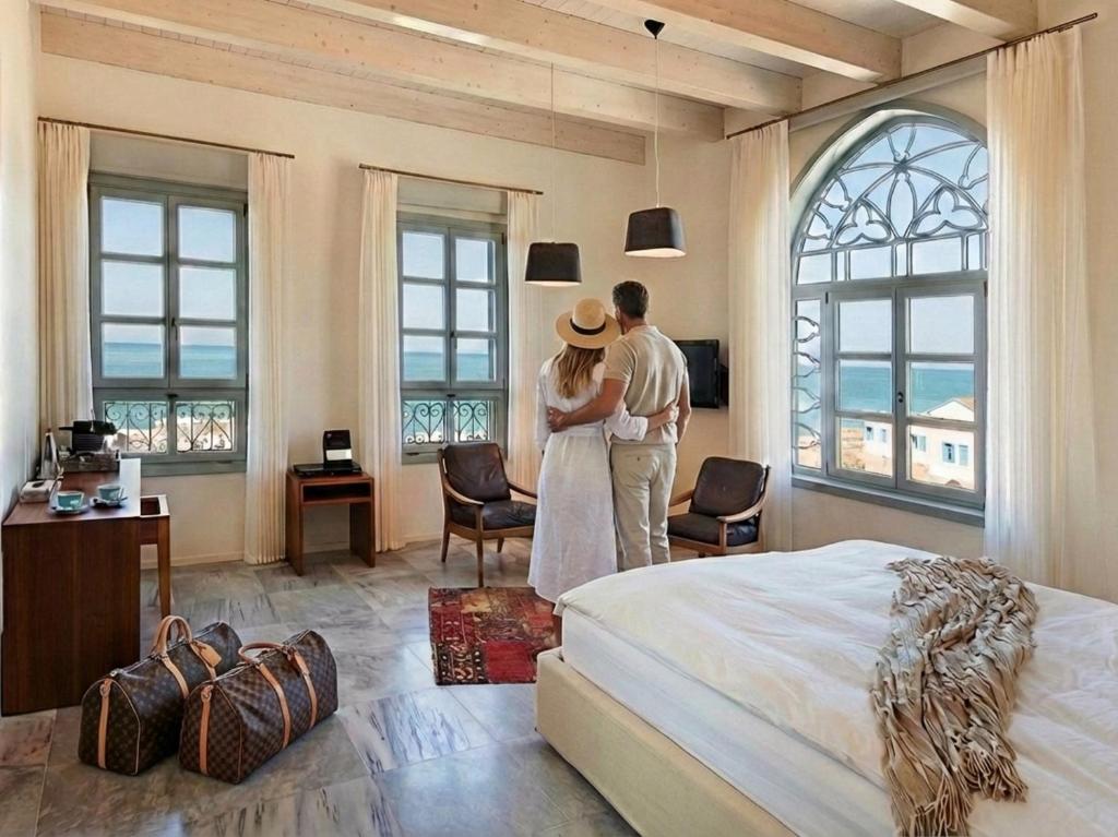 a man and woman standing in a room with a bed at The Efendi Hotel & Spa - Akko in Acre