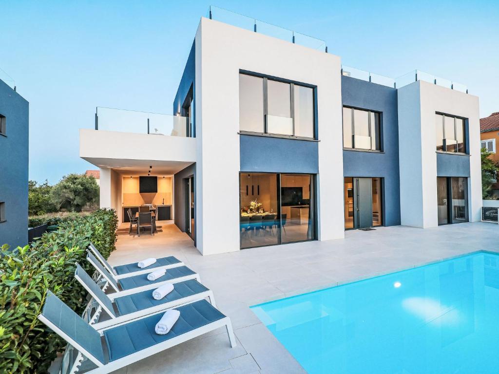 a modern house with a swimming pool and chairs at Villa Magic Sky 1 by Interhome in Kraj