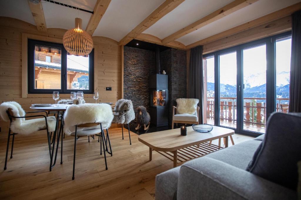 a living room with a table and chairs and a couch at Alpine Hygge by Villars Luxury in Villars-sur-Ollon