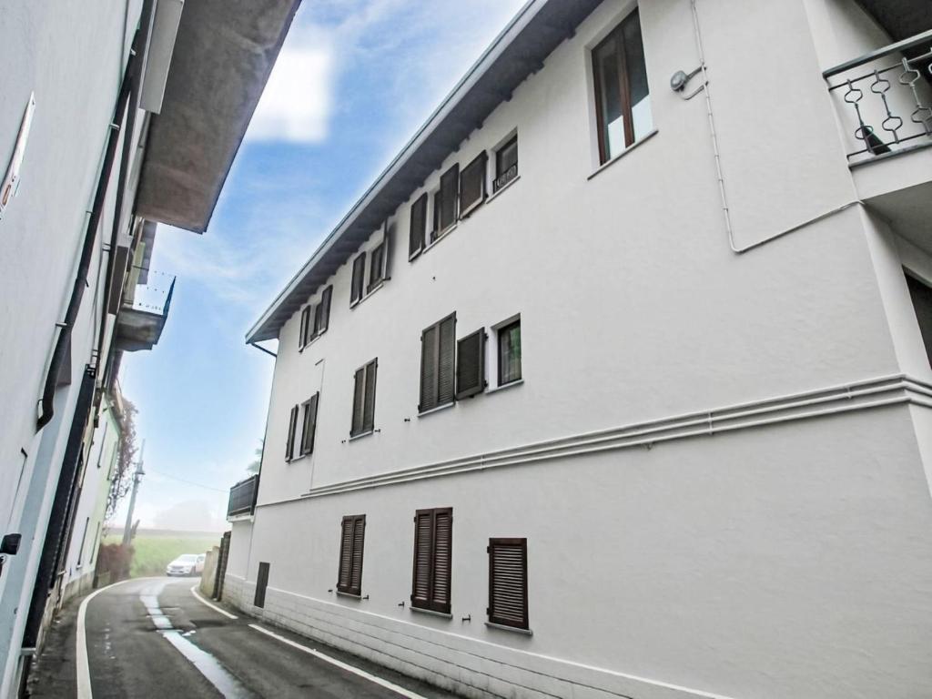 a white building with windows on a street at Apartment Amarena by Interhome in Dormelletto