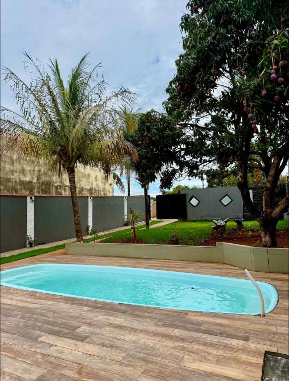 a swimming pool in a yard with palm trees at Your Climatized Paradise in Americana