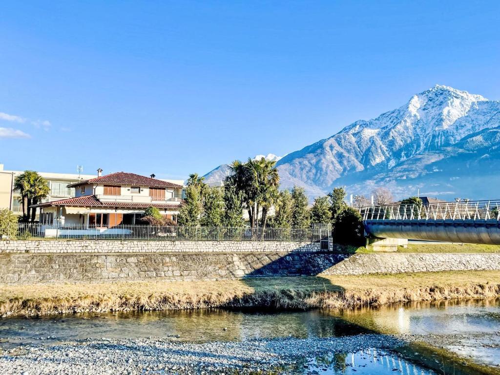 a bridge over a river with a mountain in the background at Apartment Carlui by Interhome in Domaso