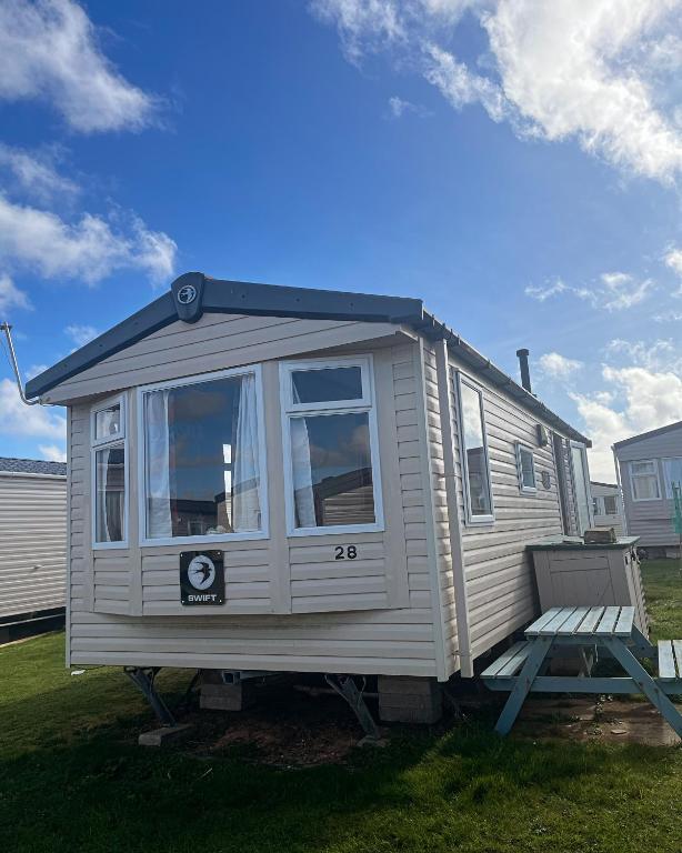 a tiny house sitting on a lawn with a bench at Sea Salt in Padstow