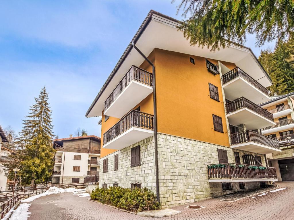 a yellow and white building with balconies at Apartment Fondue by Interhome in Madesimo