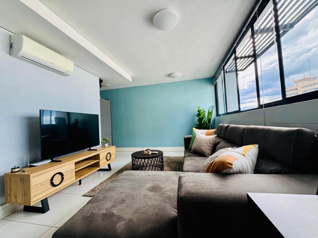 a living room with a couch and a flat screen tv at Keddy J Apartments in Windhoek