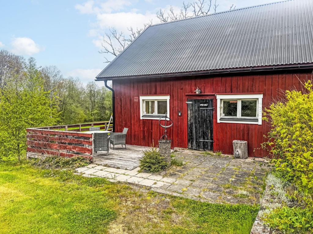 a red barn with a bench in front of it at Apartment Långerud by Interhome in Mellerud