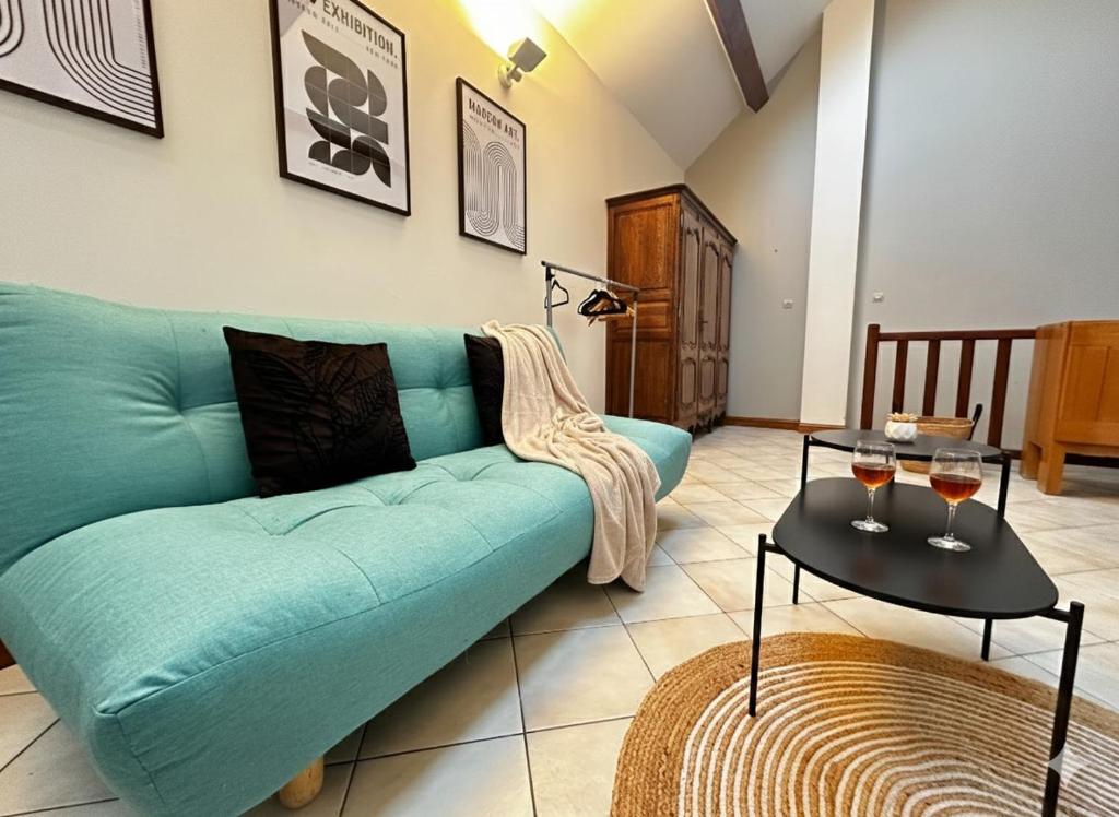 a living room with a blue couch and a table at Station Studio - Proche RER A - Wifi in Noisy-le-Grand