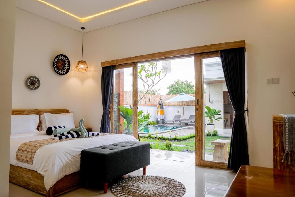 a bedroom with a bed and a large window at Ramaiin guest house in Nusa Dua