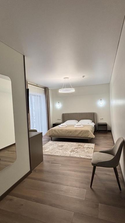 a bedroom with a bed and a chair in it at Continental SPA in Palyanytsya