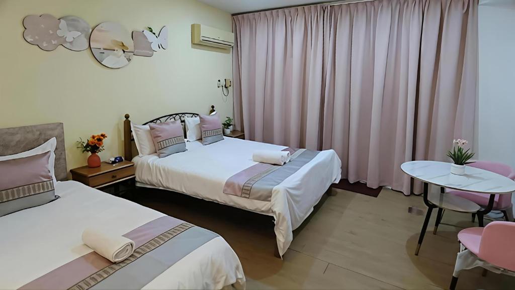 a hotel room with two beds and a table and chairs at RIVERBANK SUITE with riverfront mountain DUN view in Kuching
