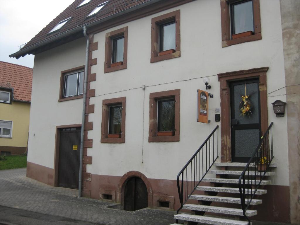 a white house with stairs and a door at Martinas-Gästehaus in Hornbach