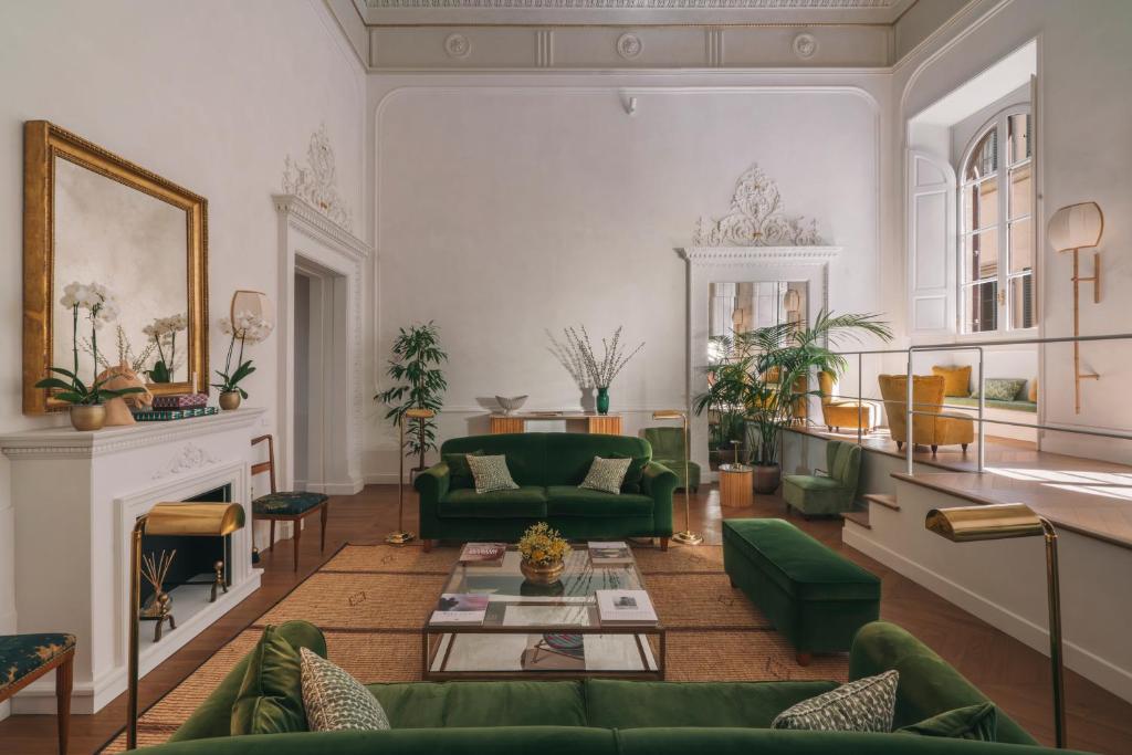 a living room with green furniture and a fireplace at Casa G. Firenze in Florence