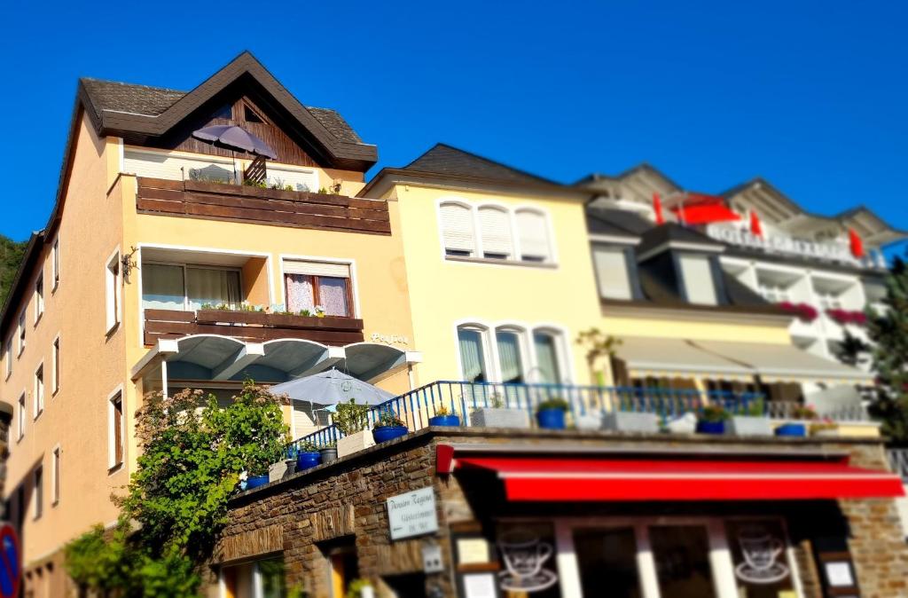 a yellow building with a balcony with umbrellas on it at Pension Regina in Cochem