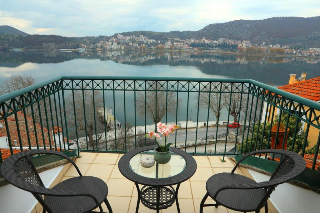 a balcony with a table and chairs and a view of a lake at Lacus Orestias - unlimited view in Kastoria