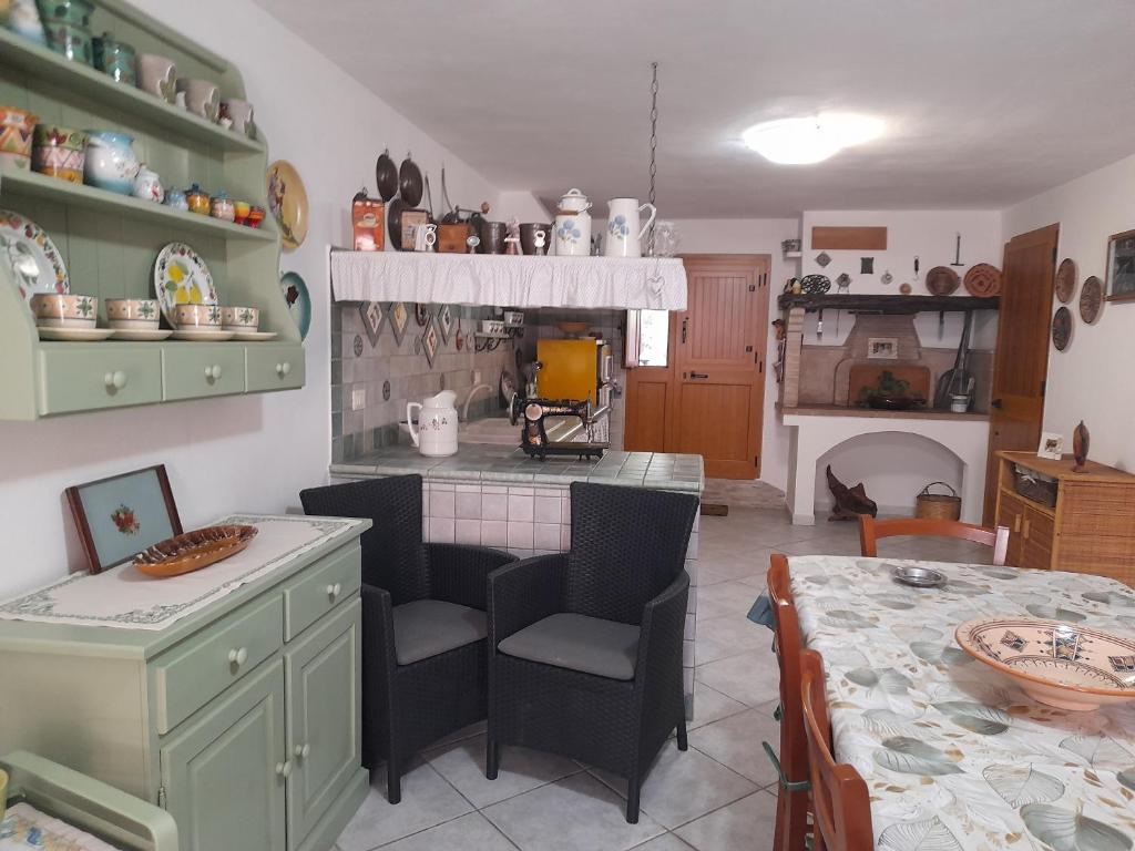 a kitchen with a table and a dining room at Casafreccia in Carloforte