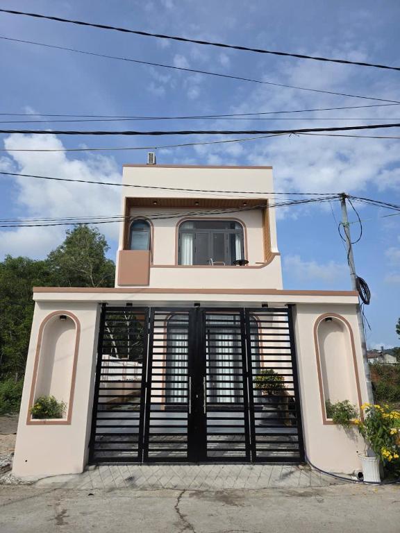 a white house with a black gate at Đức Khoa Villa Phu Quoc in Phú Quốc