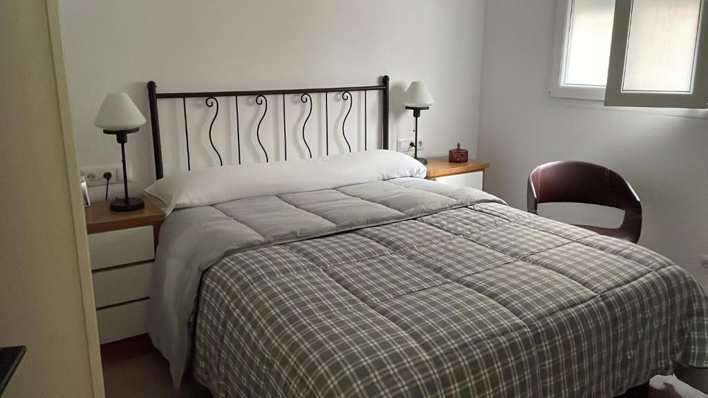 a bedroom with a bed and two chairs and a window at Casa Bueu Pontevedra in Bueu