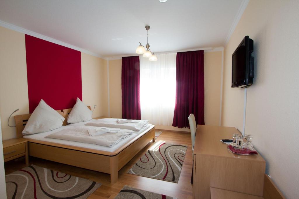 Schlafzimmer mit einem Bett, einem Tisch und einem TV in der Unterkunft Hotel Rhein-Mosel-View in Koblenz