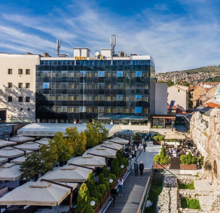 un edificio con un mucchio di ombrelli di fronte di Hotel Art a Sarajevo