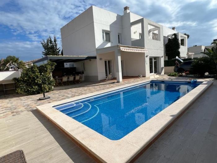 a large swimming pool in front of a house at 32 Salamandre in Les tres Cales