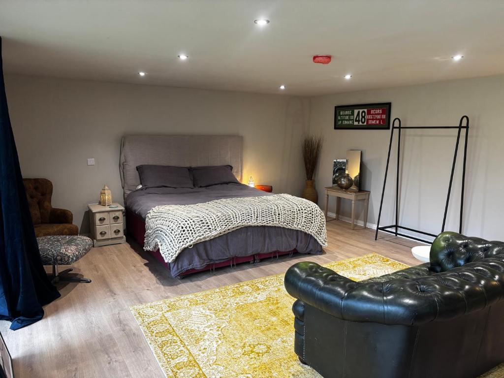 a bedroom with a bed and a couch at The Cabin in St. Ives