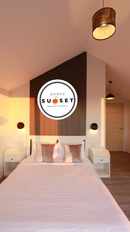 a bedroom with a bed with a sign on the wall at Wawee Sunset, Doi Chang Chiang Rai in Ban Huai Khai