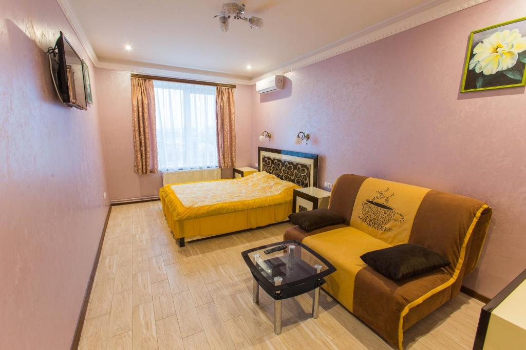 uma sala de estar com um sofá e uma cama em Modern apartment on Akademika Sakharova 27a em Ivano-Frankivsk
