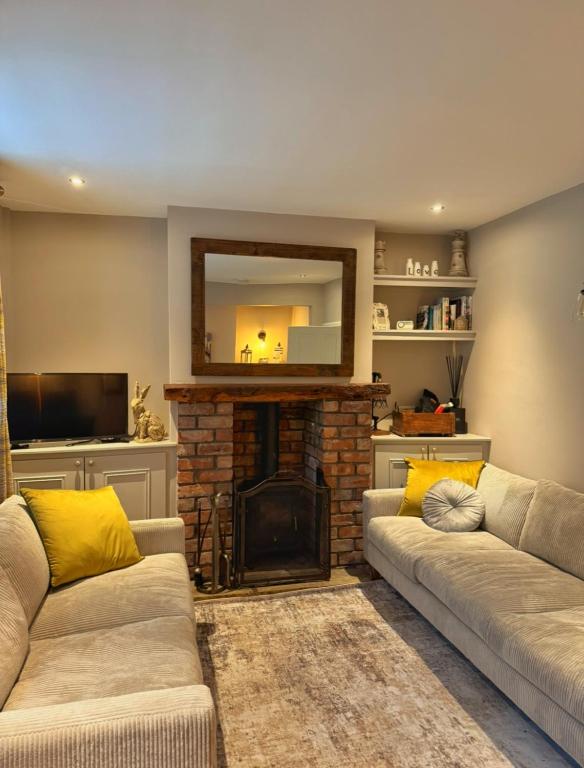 a living room with two couches and a fireplace at No 1 Chapel Row in Bakewell