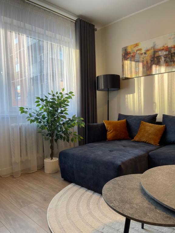 a living room with a blue couch and a table at Golden corner in Plungė