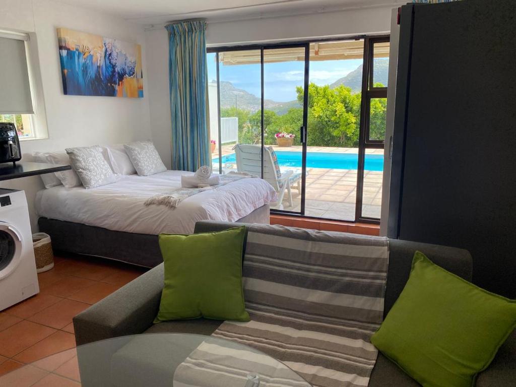 a living room with a bed and a couch and a pool at Seaview in Hout Bay