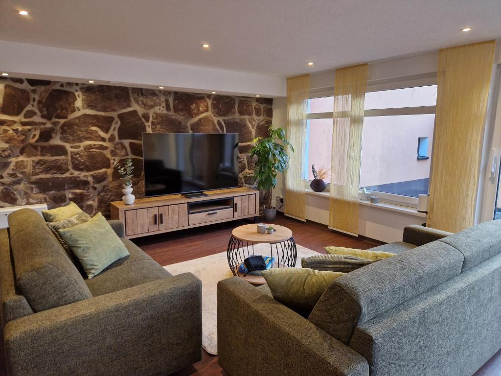 a living room with two couches and a flat screen tv at Ferienwohnung Zum Alten Cafè in Neustadt